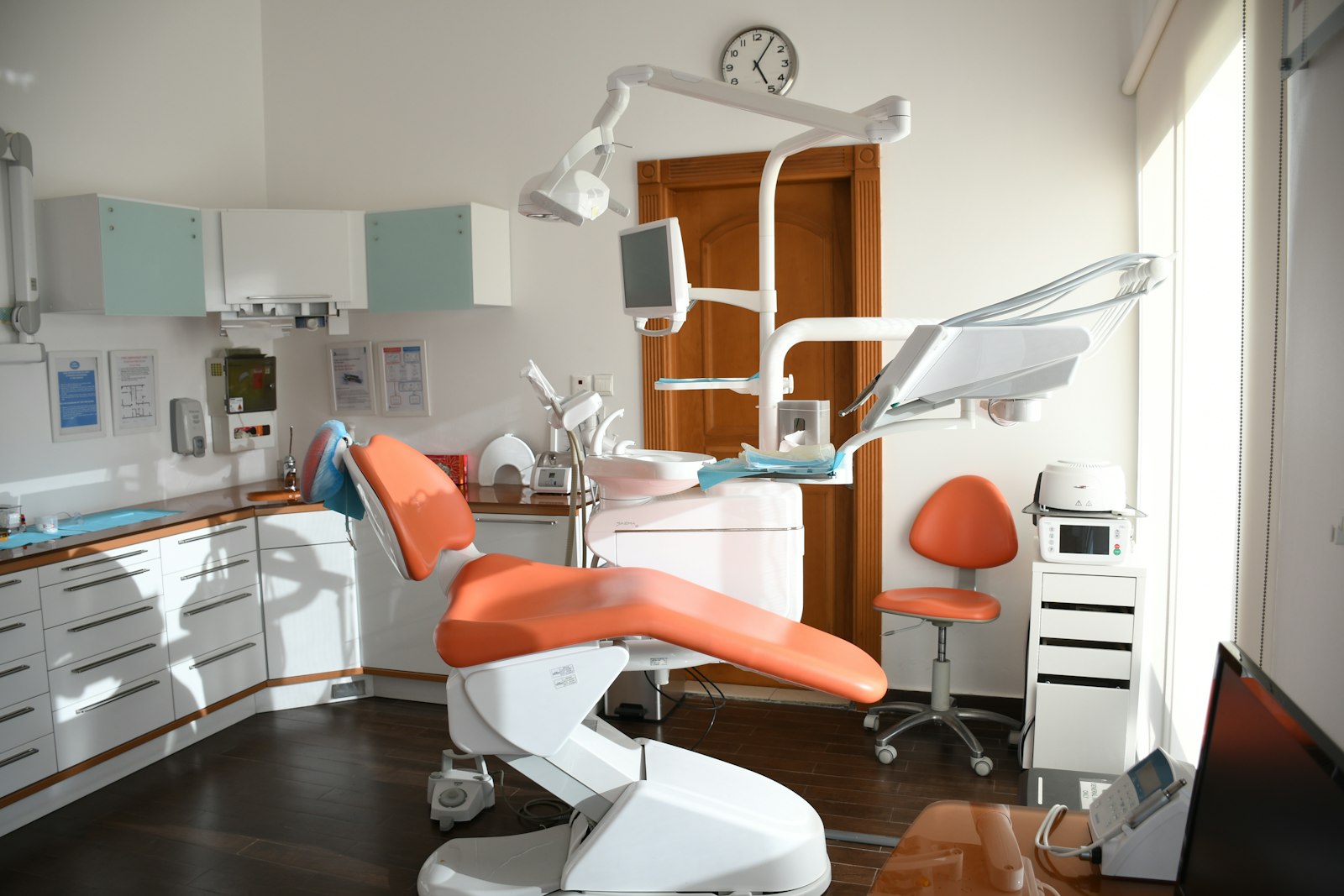 Sunlit dental operatory with an orange treatment chair